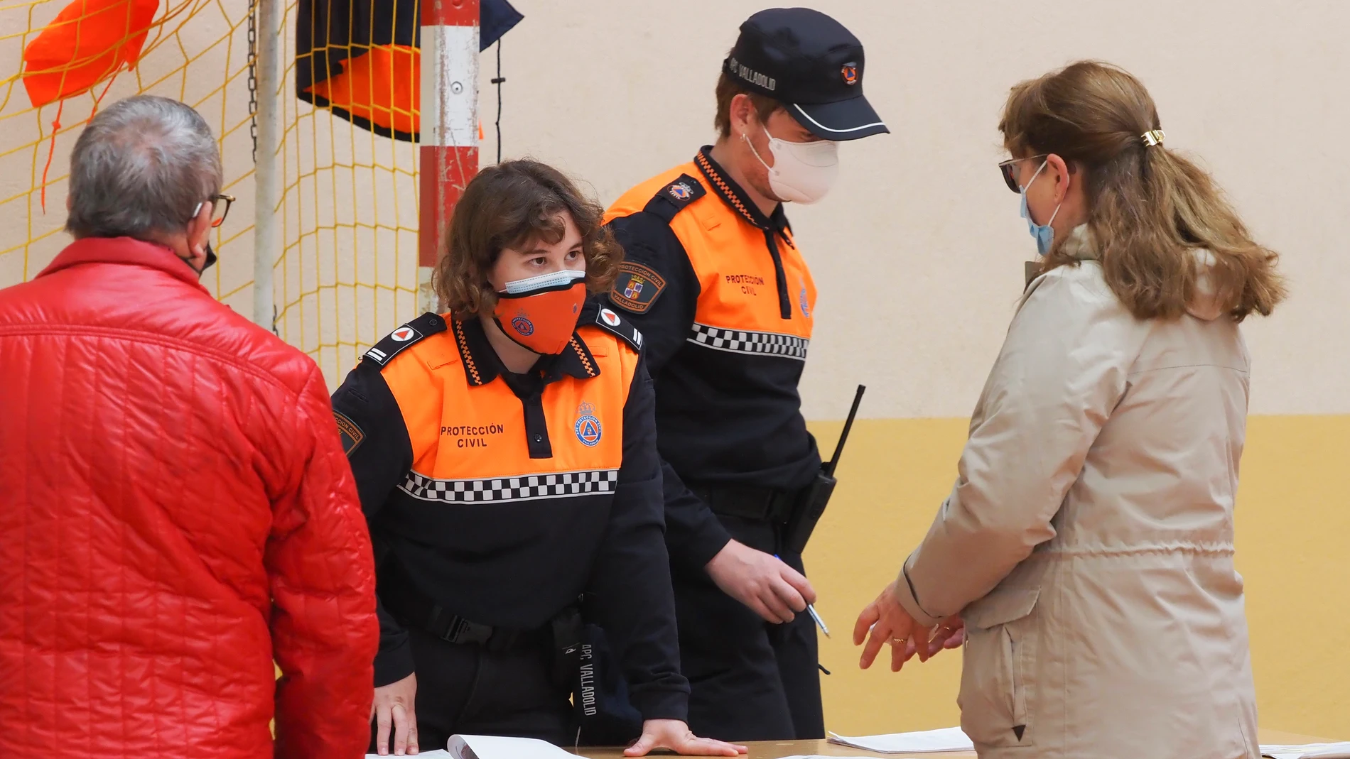 Dos agentes de Protección Civil ayudan a dos vecinos dela localidad vallisoletana de Pedrajas de San Esteban durante un cribado masivo