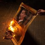 Un manifestante quema una foto del rey Felipe VI en Barcelona.