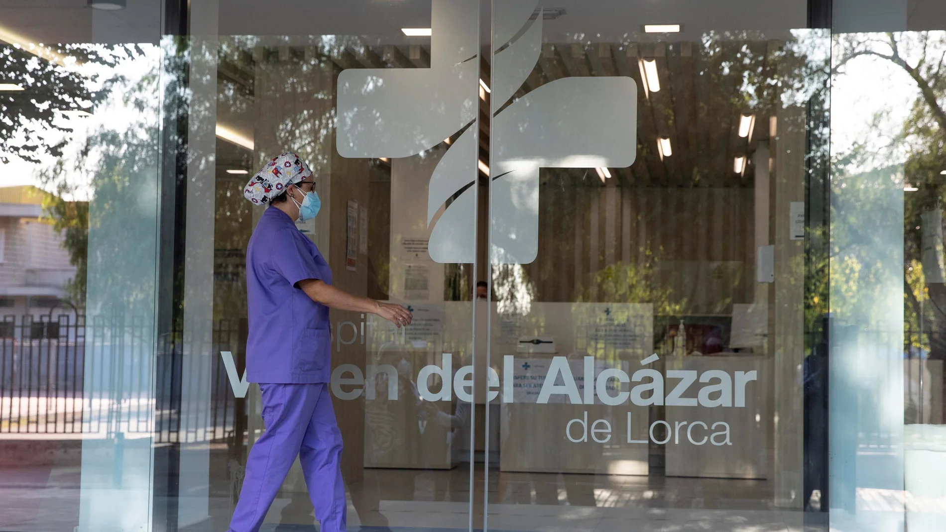 Una enfermera se dispone a entrar por la puerta principal del Hospital privado concertado Virgen del Alcázar de Lorca (Murcia), donde se detectó un brote de coronavirus el pasado sábado que afecta ya a 63 personas