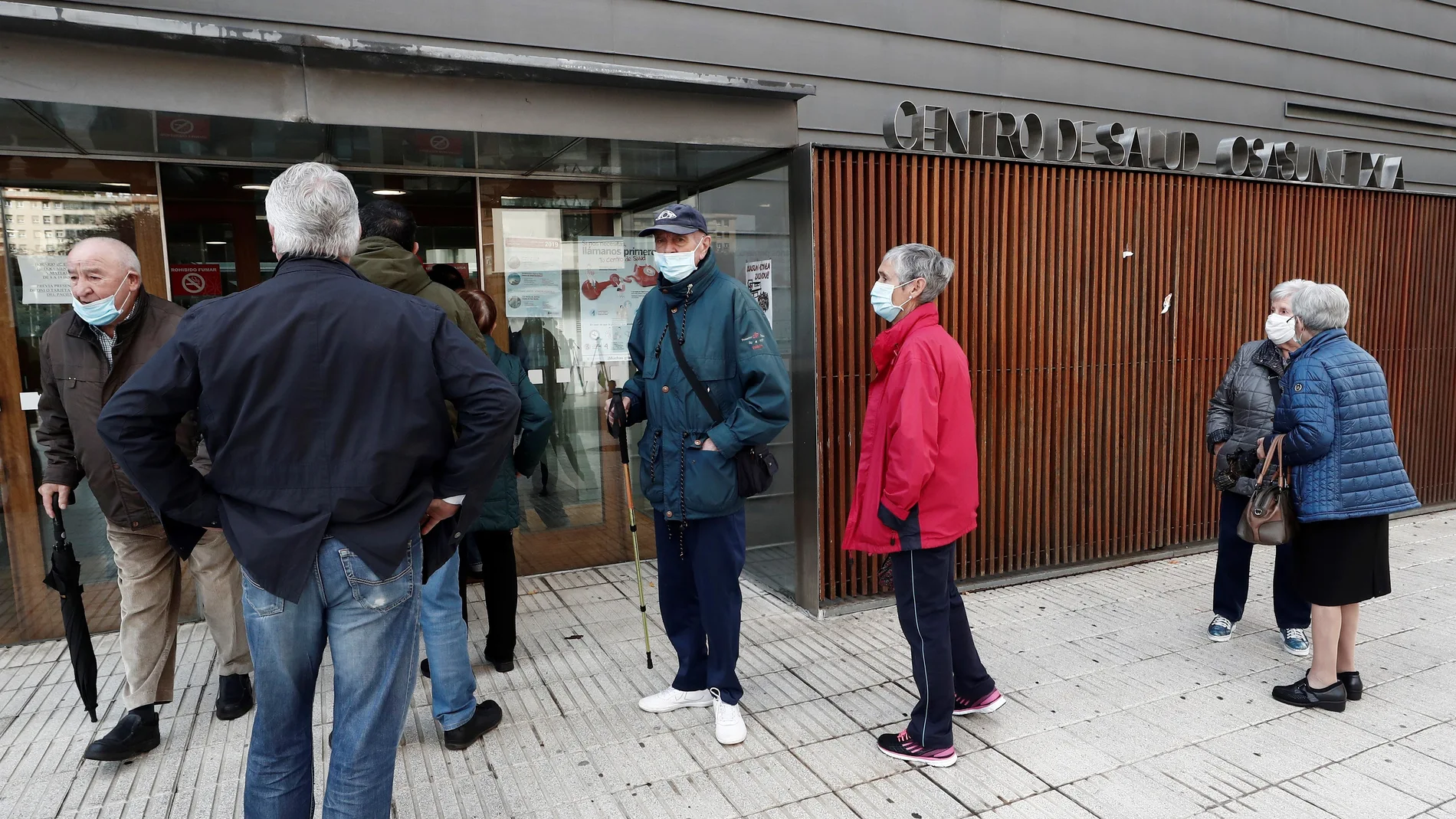 Un grupo de personas esperan en el exterior de un centro de salud de Pamplona para ponerse la vacuna contra la gripe