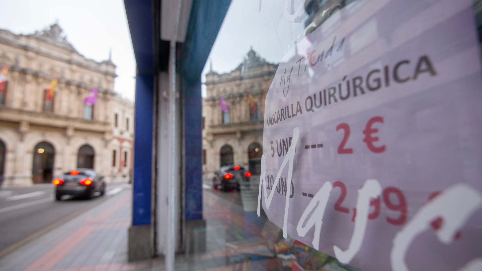 La fachada de la Diputación de Palencia en la Calle Burgos reflejada en un local donde se venden mascarillas quirúrgicas, Palencia, Castilla y León (España),