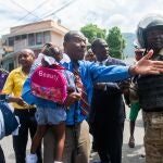 AME9448. PUERTO PRÍNCIPE (HAITÍ), 05/10/2020.- Un hombre habla con unos policías durante una protesta, este lunes, por la muerte del estudiante Grégory Saint-Hilaire, fallecido supuestamente por tiros de un policía de la guardia presidencial el pasado 2 de octubre en Puerto Príncipe (Haití). Al menos un manifestante murió en las protestas de este lunes, que coinciden con una advertencia hecha este lunes por el Consejo de Seguridad de la ONU por el riesgo de que estas tensiones desestabilicen Haití. EFE/ Jean Marc Herve Abelard