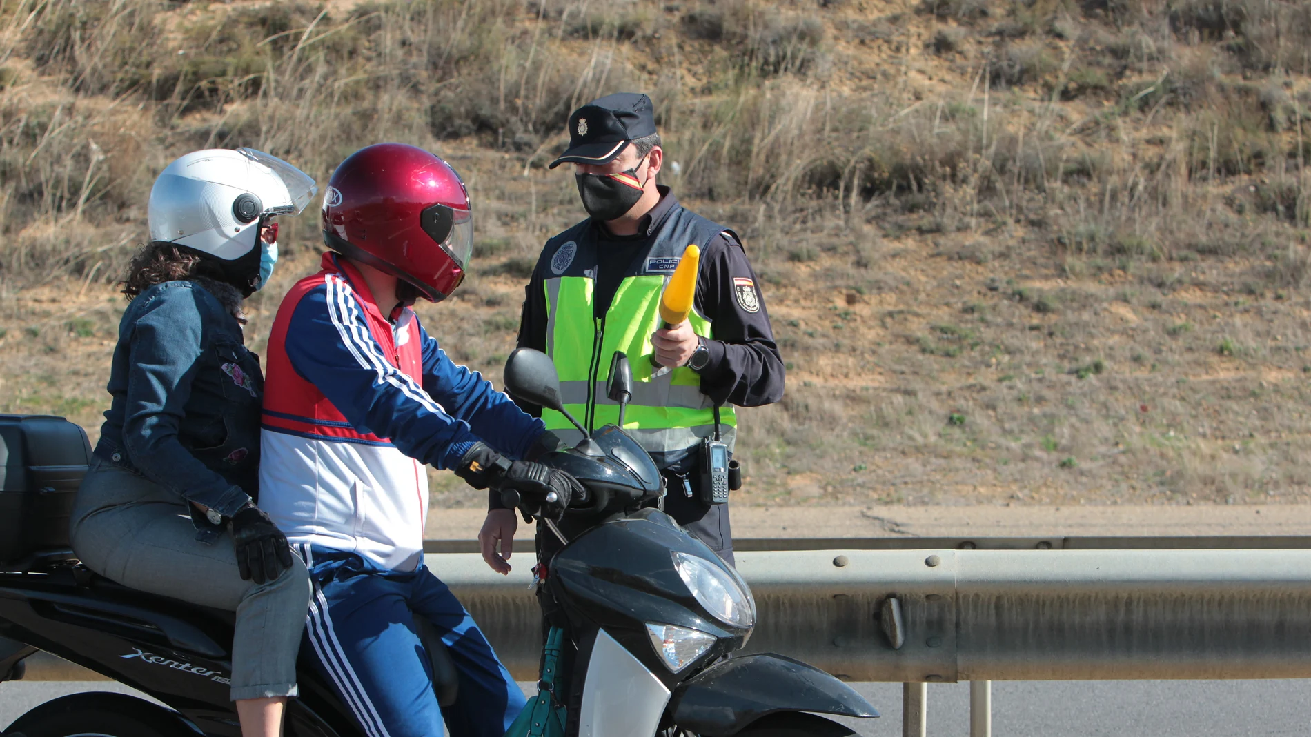 Una moto pasa junto a un agente de la Guardia Civil en un control policial en León