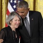 FILE - In this Thursday, Sept. 22, 2016 file photo, President Barack Obama embraces poet Louise Gluck before awarding her the 2015 National Humanities Medal during a ceremony in the East Room of the White House, in Washington. The 2020 Nobel Prize for literature has been awarded to American poet Louise Gluck â€œfor her unmistakable poetic voice that with austere beauty makes individual existence universal.â€ The prize was announced Thursday Oct. 8, 2020 in Stockholm by Mats Malm, the permanent secretary of the Swedish Academy. (AP Photo/Carolyn Kaster, File)