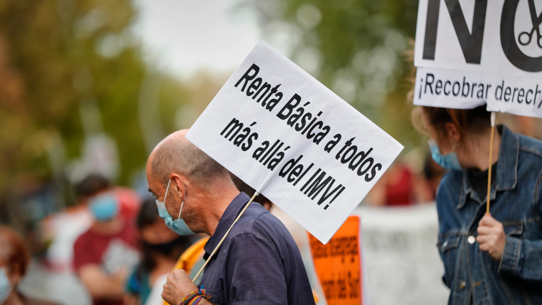 Un hombre sostiene un cartel en el que se lee "Renta Básica a todos más allá del IMV" durante una concentración celebrada en octubre pasado