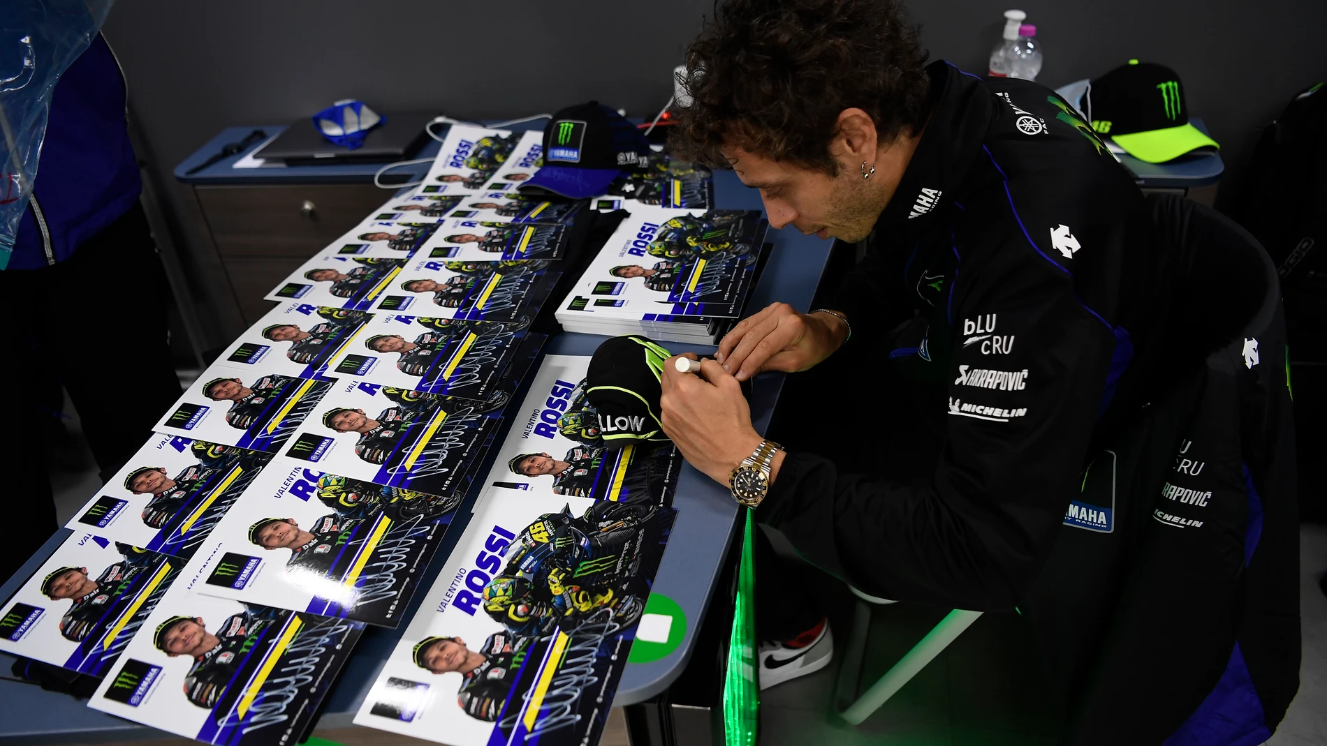 Valentino Rossi firma fotos suyas en la previa del Gran Premio de Francia en Le Mans