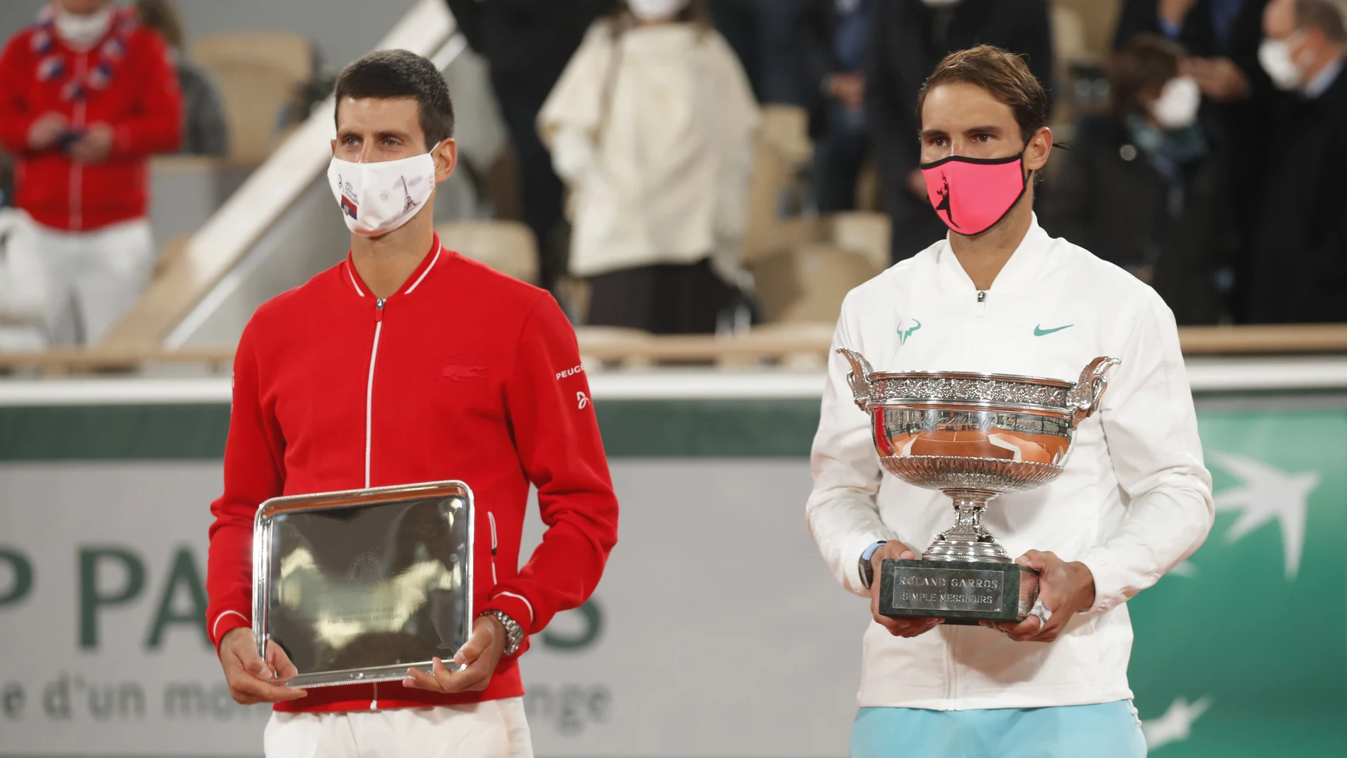 Rafa Nadal posa con el trofeo de campeón de Roland Garros y Novak Djokovic con el de finalista.
