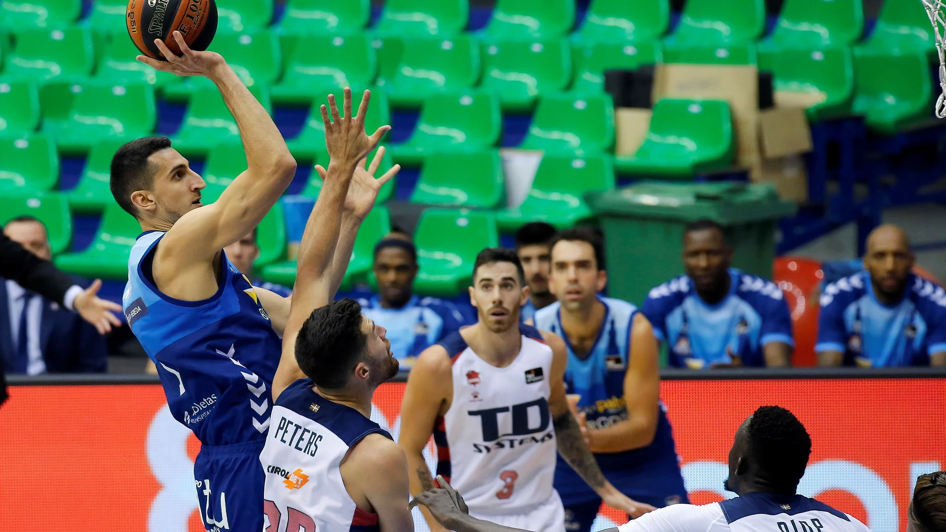 El pivot bosnio de San Pablo Burgos, Dejan Kravic (i), lanza a canasta ante los jugadores del TD Systems Baskonia, el estadounidense Alec Peters (2i) e Ilimane Diop, durante el encuentro correspondiente a la quinta jornada de la Liga Endesa disputado esta tarde en el pabellón multiusos Coliseum Burgos. EFE/Santi Otero.