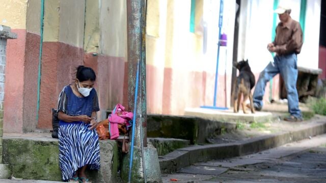 Una mujer descansa en una acera hoy, en el municipio de Valle de Ángeles (Honduras). La pandemia de COVID-19 acentuará la pobreza y la desigualdad en Honduras, donde la enfermedad no ha logrado detener la corrupción,