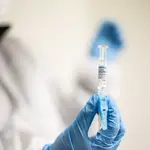 Un enfermero sostiene una de las vacunas contra la gripe que durante el día de hoy ha inyectado en el recinto habilitado en el Iradier Arena, en Vitoria