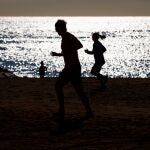Varias personas practican deporte en la playa de la Barceloneta