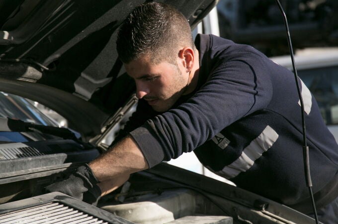 Una persona repara un coche en un taller