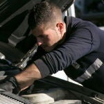 Una persona repara un coche en un taller