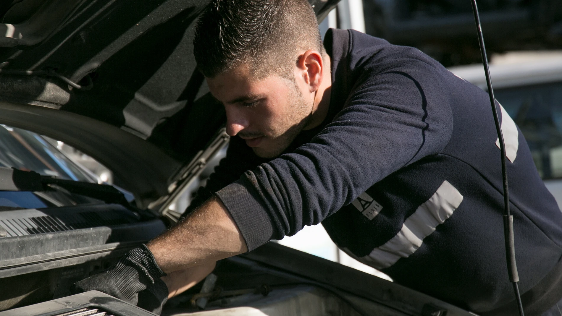 Una persona repara un coche en un taller