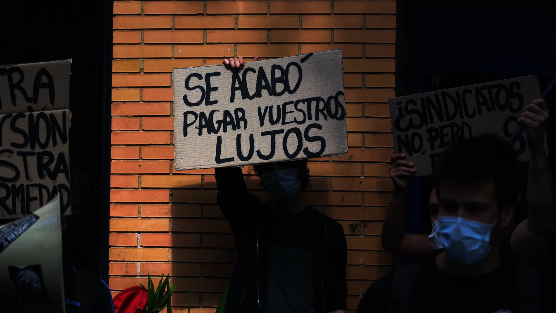 Un estudiante sostiene un cartel en el que se lee 'Se acabó pagar vuestros lujos' durante una concentración convocada por el sindicato 'Estudiantes en Lucha' en la residencia Galileo Galilei, en Valencia