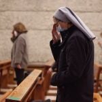 Una monja reza durante la celebración de la Santa Eucaristía en la Parroquia de Santa Elena, en Madrid (España)