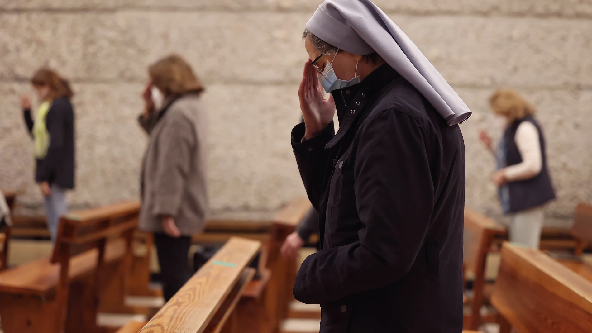 Una monja reza durante la celebración de la Santa Eucaristía en la Parroquia de Santa Elena, en Madrid (España)