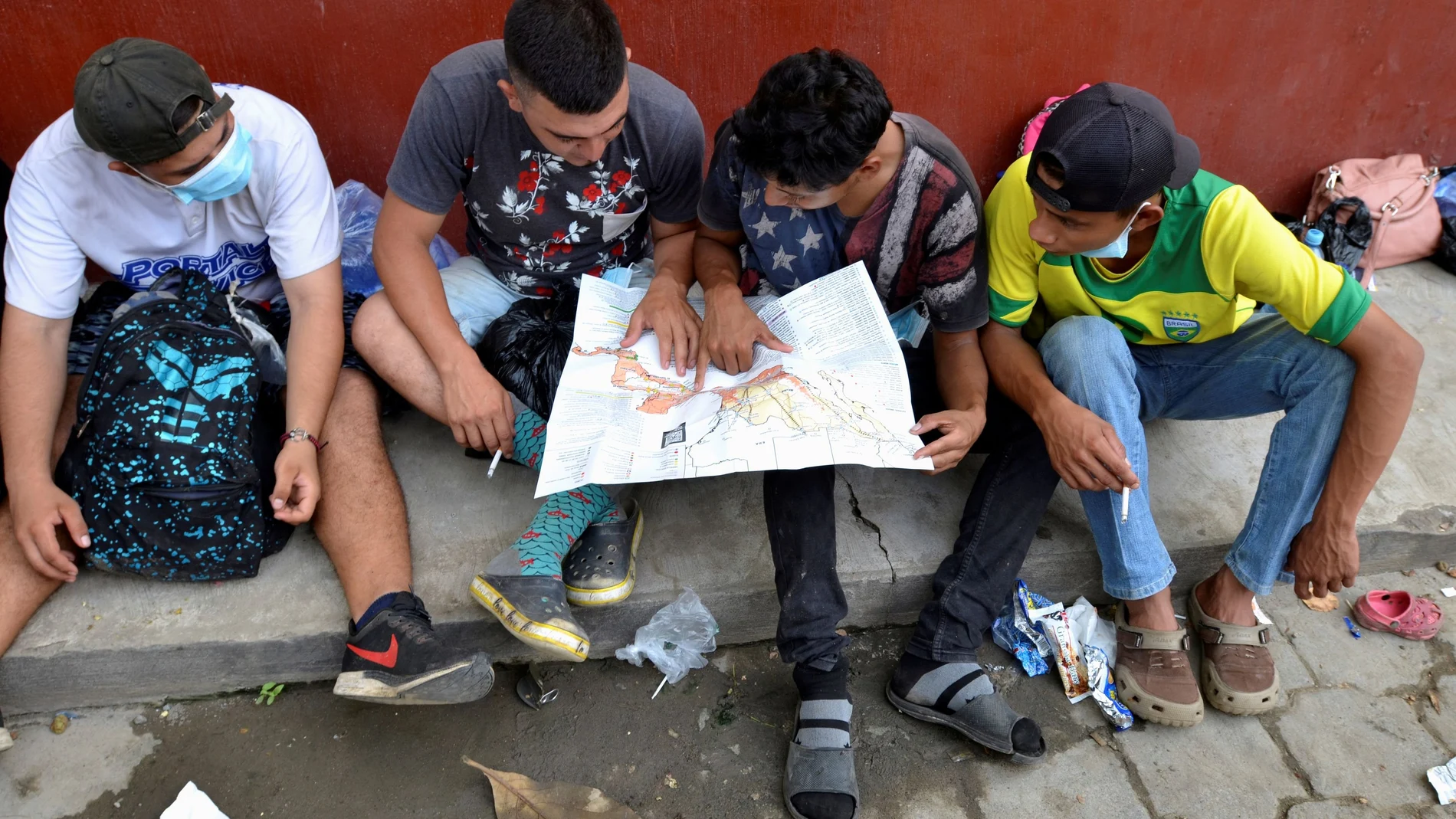FILE PHOTO: A group of Honduran migrants who are trying to reach the U.S. , look at a Central America and Mexico map outside a migrant shelter as they wait to move towards the Guatemala and Mexico border, in Tecun Uman, Guatemala October 3, 2020. REUTERS/Jose Torres//File Photo