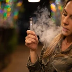 Una mujer fuma un cigarrillo electrónico