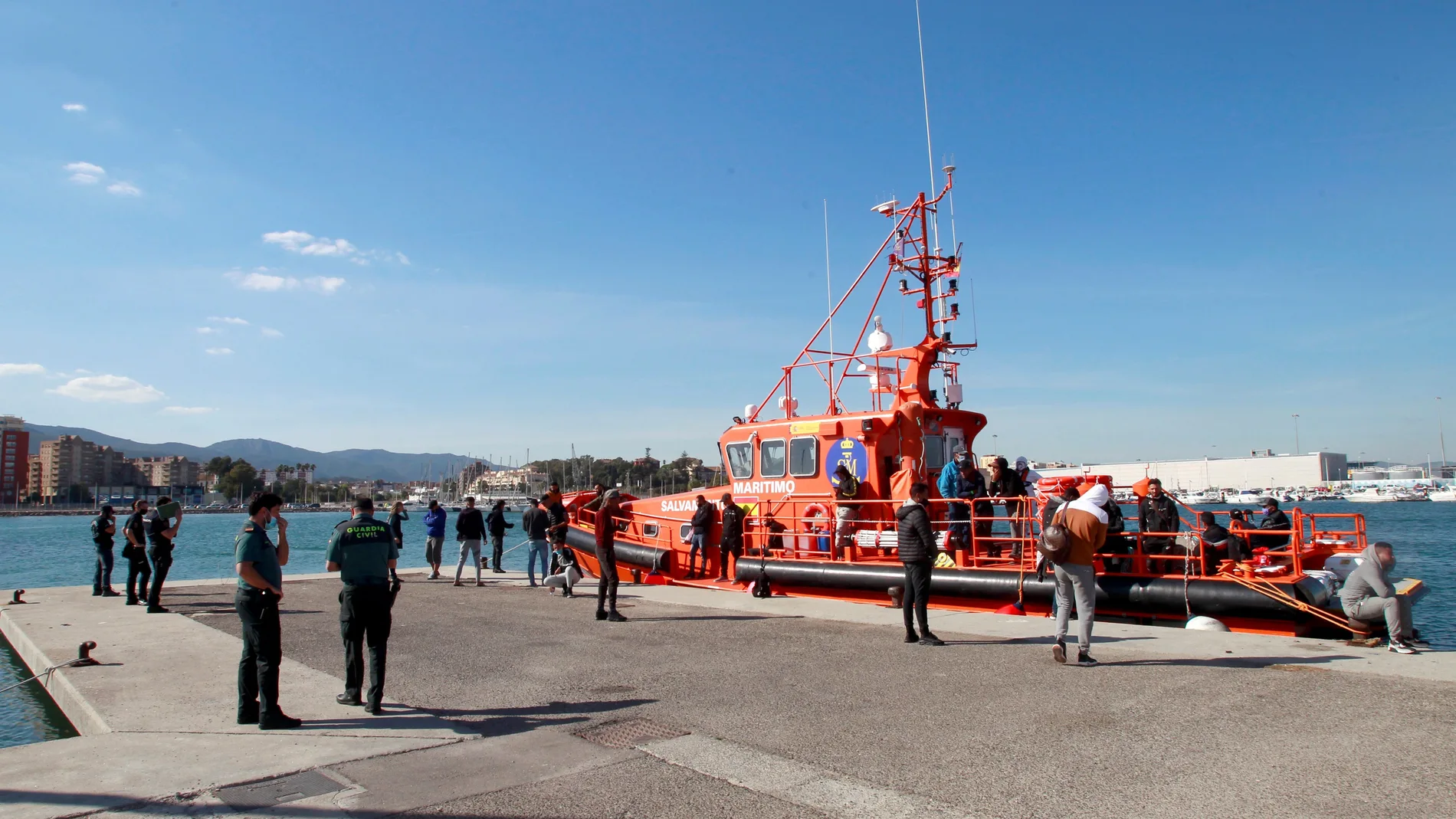 Efectivos de la Guardia Civil y de la Policía Nacional vigilan en el puerto de Algeciras a algunos inmigrantes rescatados