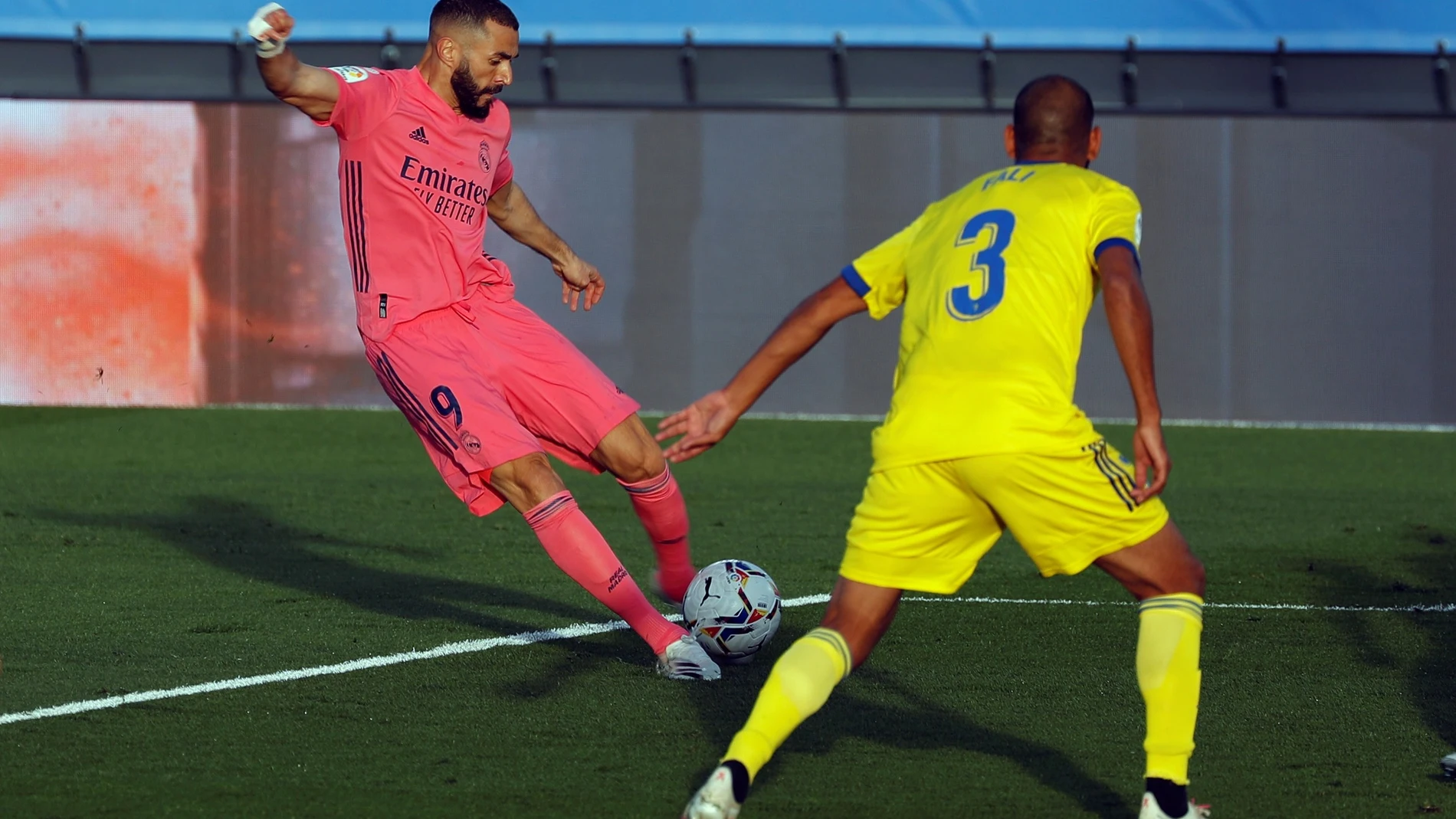 El delantero francés del Real Madrid Karim Benzemá (i) juega un balón ante Fali, del Cádiz