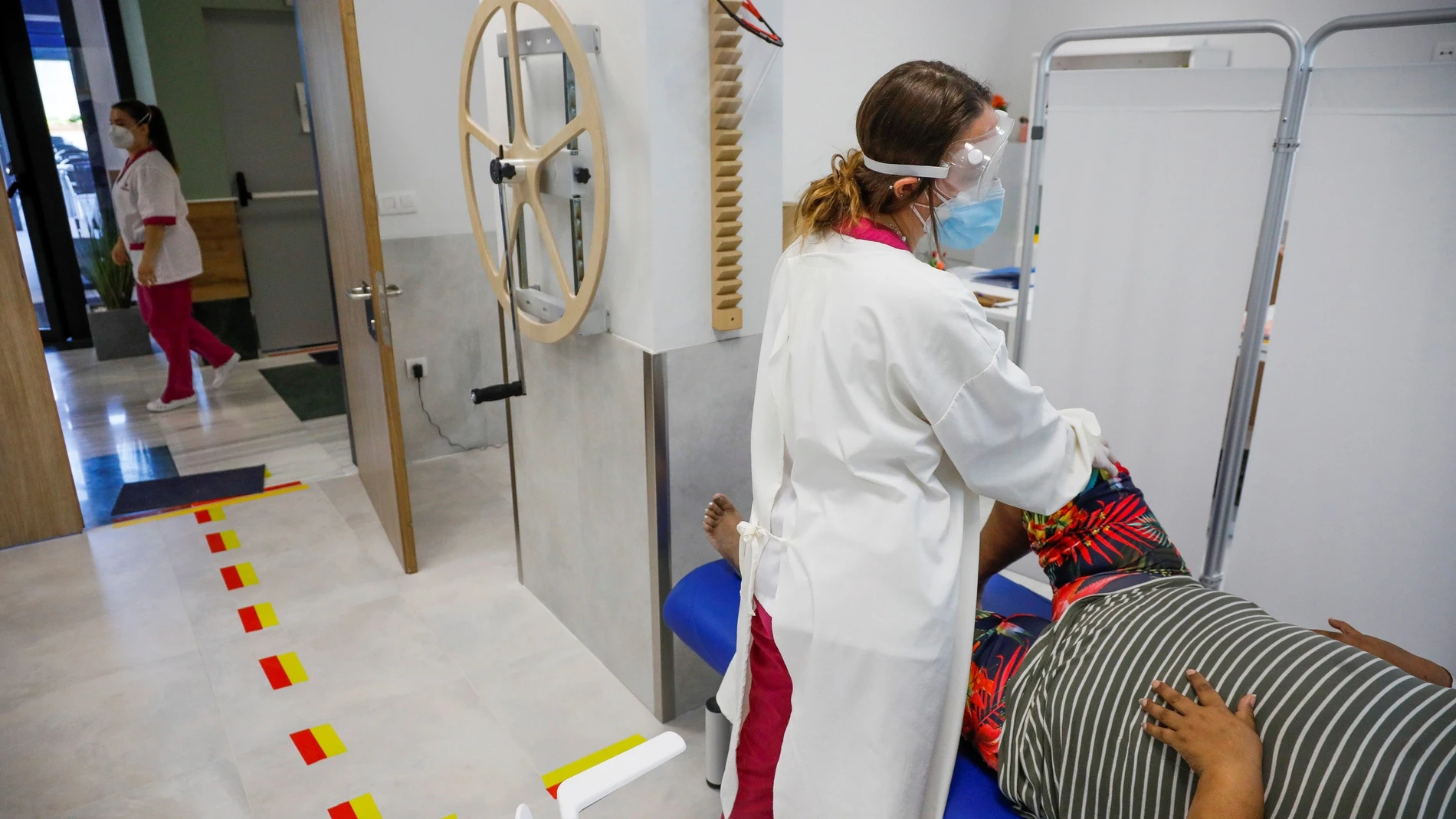 Una, fisioterapeuta de la residencia de mayores "Vitalia Canillejas" trata a una paciente, en las instalaciones del centro en Madrid
