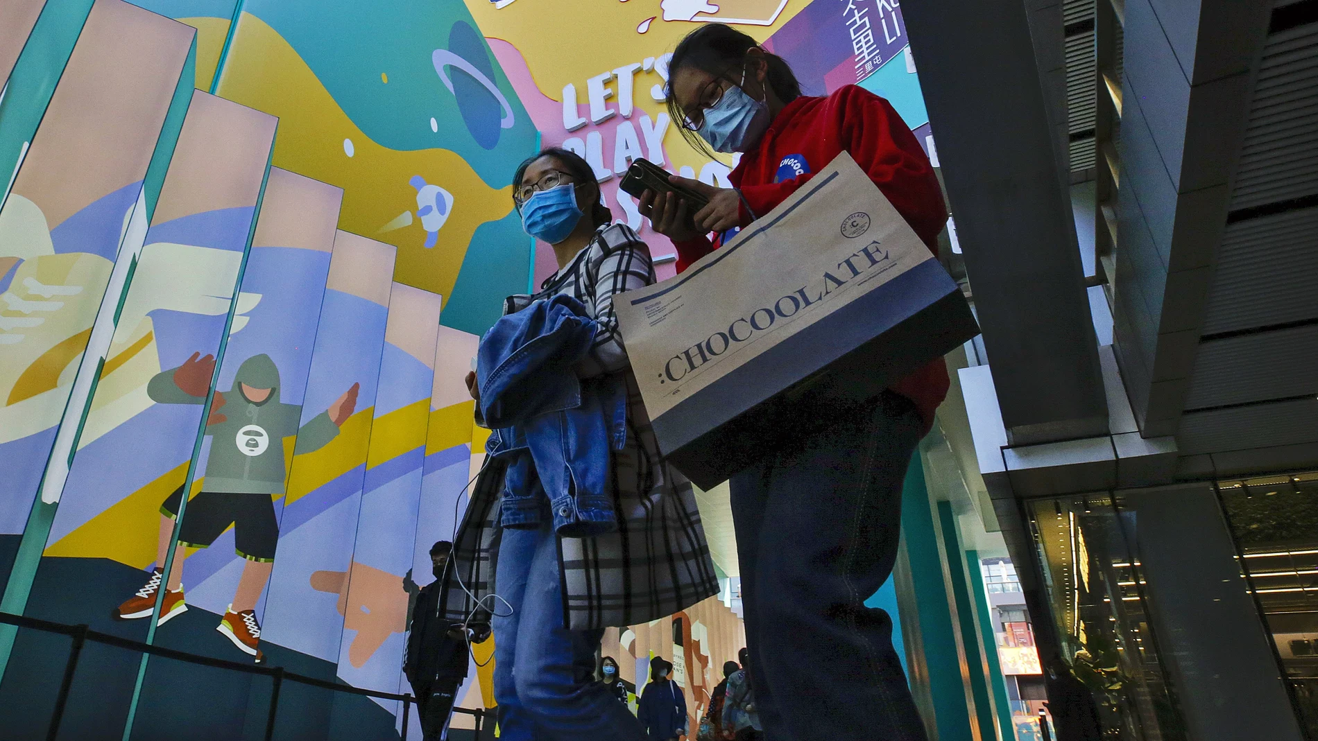 Dos mujeres con mascarilla en un popular centro comercial en Beijing