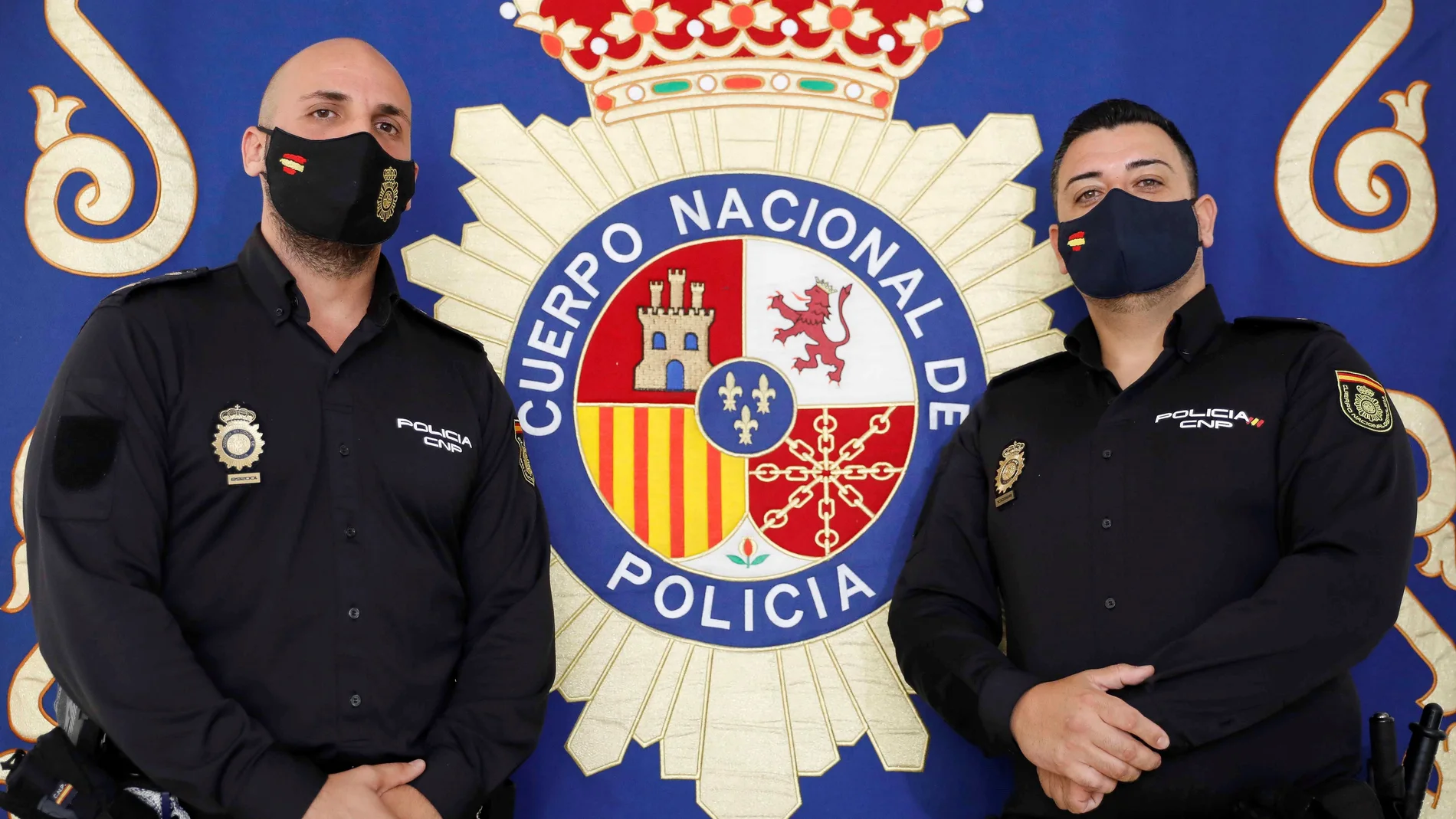 Los dos agentes de la Policía Nacional pertenecientes al Grupo de Atención al Ciudadano de Valencia, que salvaron la vida a una niña que se había desvanecido y no respiraba el pasado sábado, posan en la Jefatura Superior de Valencia