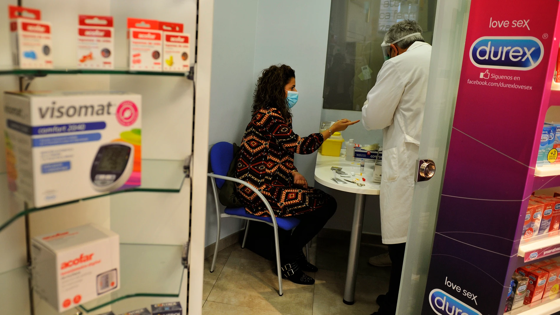Un farmacéutico de la Farmacia Da-Cunha toma una muestra de sangre para realizar un test de cribado del coronavirus en Barbadás, en Orense
