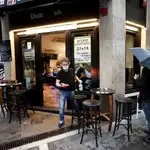 Un camarero se dispone a desinfectar el mobiliario de un bar en Navarra