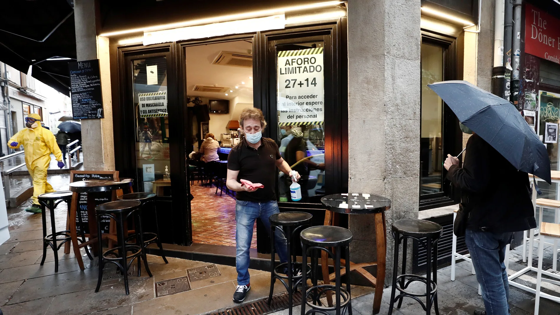 Un camarero se dispone a desinfectar el mobiliario de un bar en Navarra