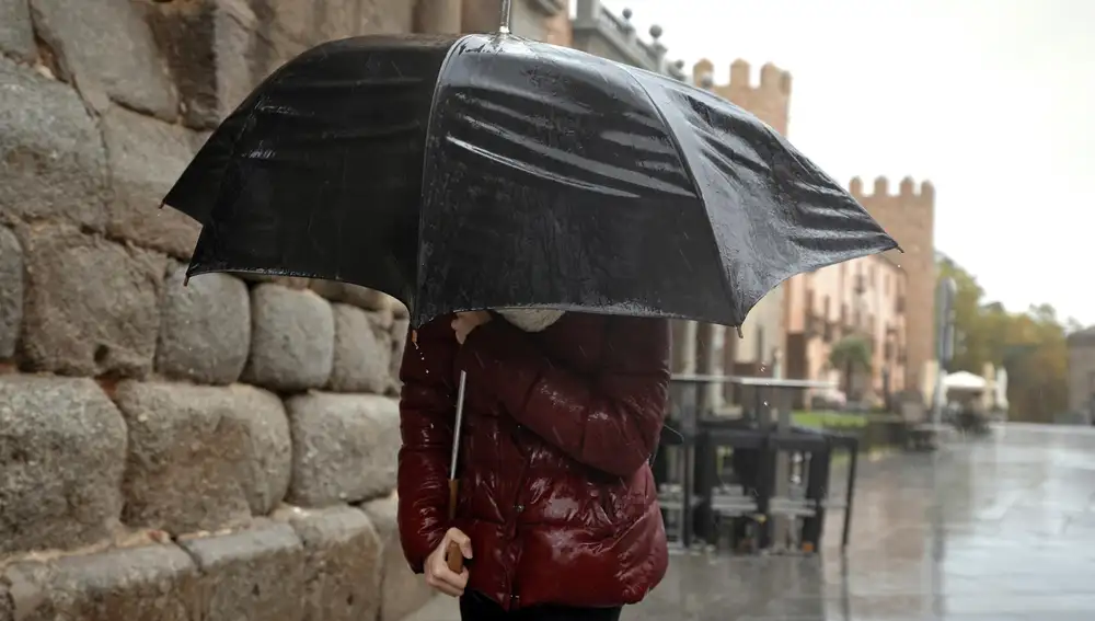 Una persona se protege de la lluvia este martes en Ávila