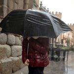 Una persona se protege de la lluvia este martes en Ávila