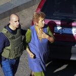 Un policía georgiano escolta a una mujer que ha logrado escapar del banco donde un hombre armado ha tomado a varios rehenes en Zugdidi al oeste de Georgia