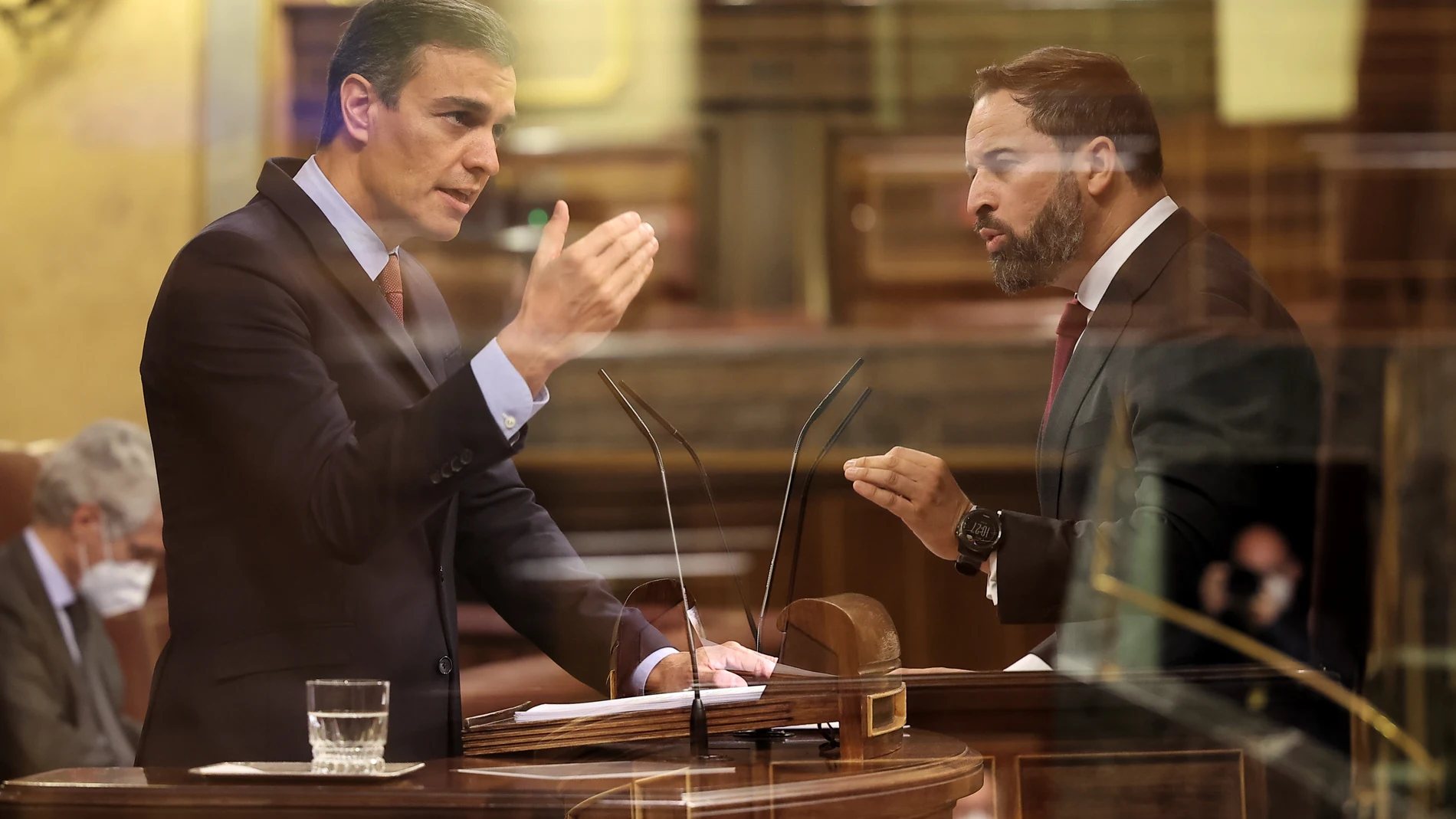 El presidente del Gobierno, Pedro Sánchez, y el líder de VOX, Santiago Abascal, durante su intervención en el pleno