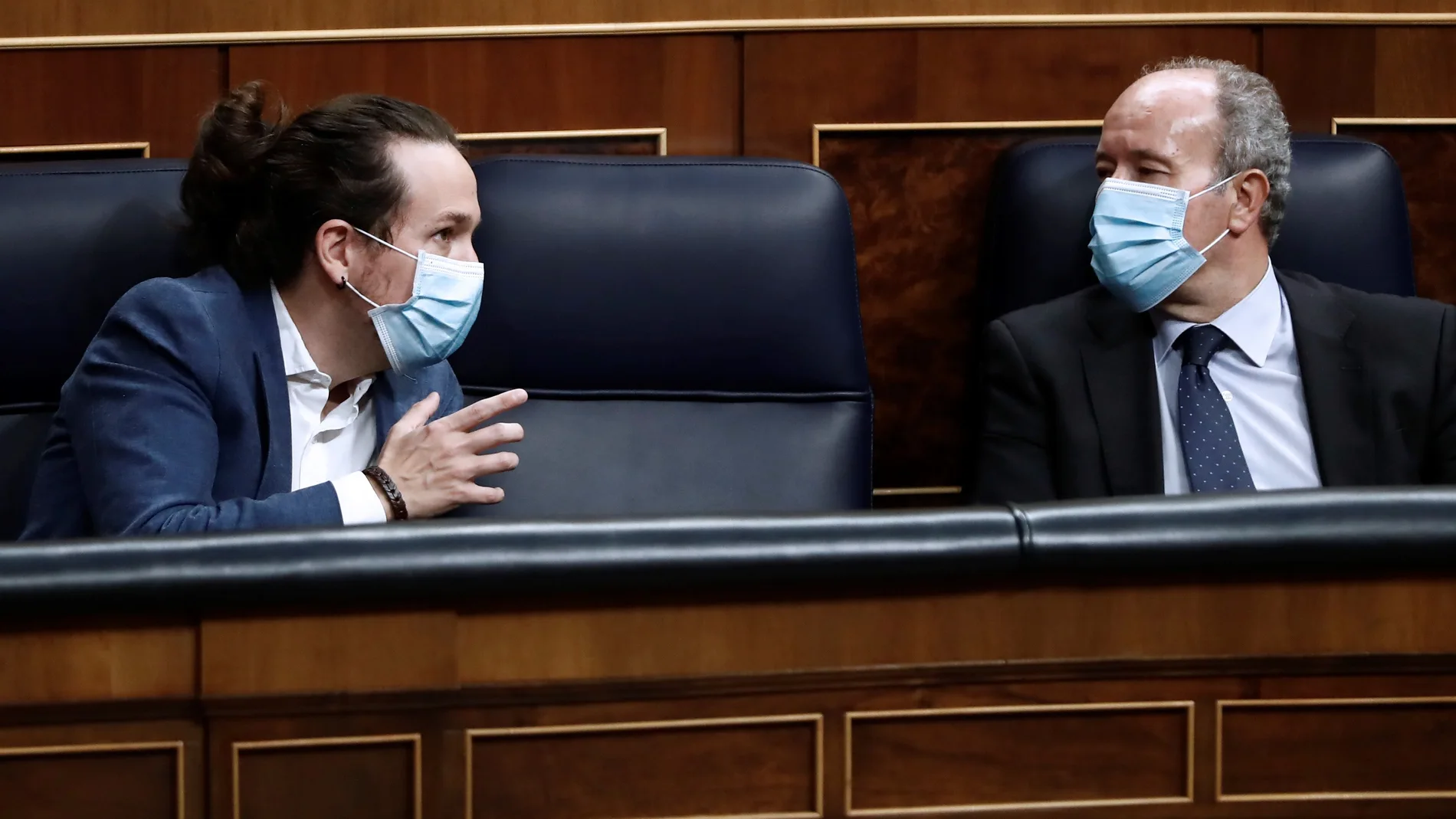 El vicepresidente segundo, Pablo Iglesias (i), conversa con el ministro de Justicia, Juan Carlos Campo, en el Congreso