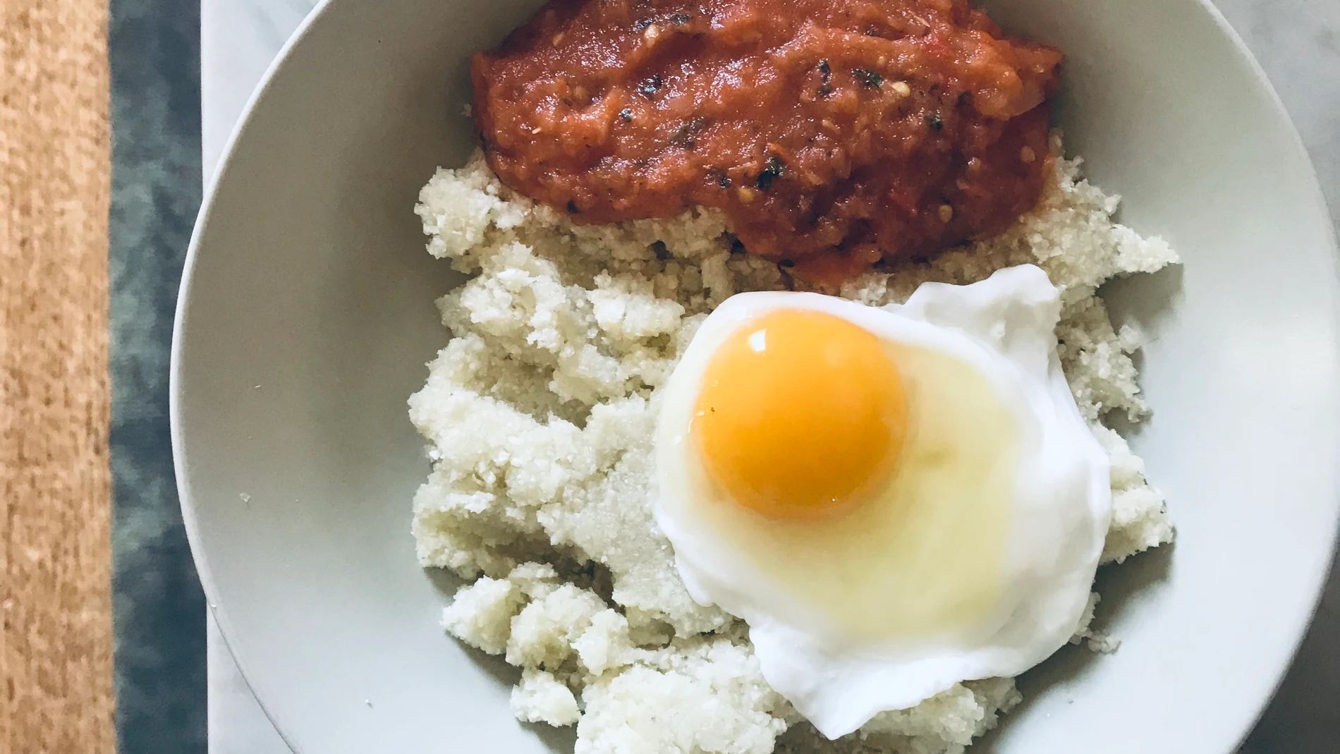 En la imagen, un plato de falso arroz de coliflor con tomate casero y huevo frito al agua.