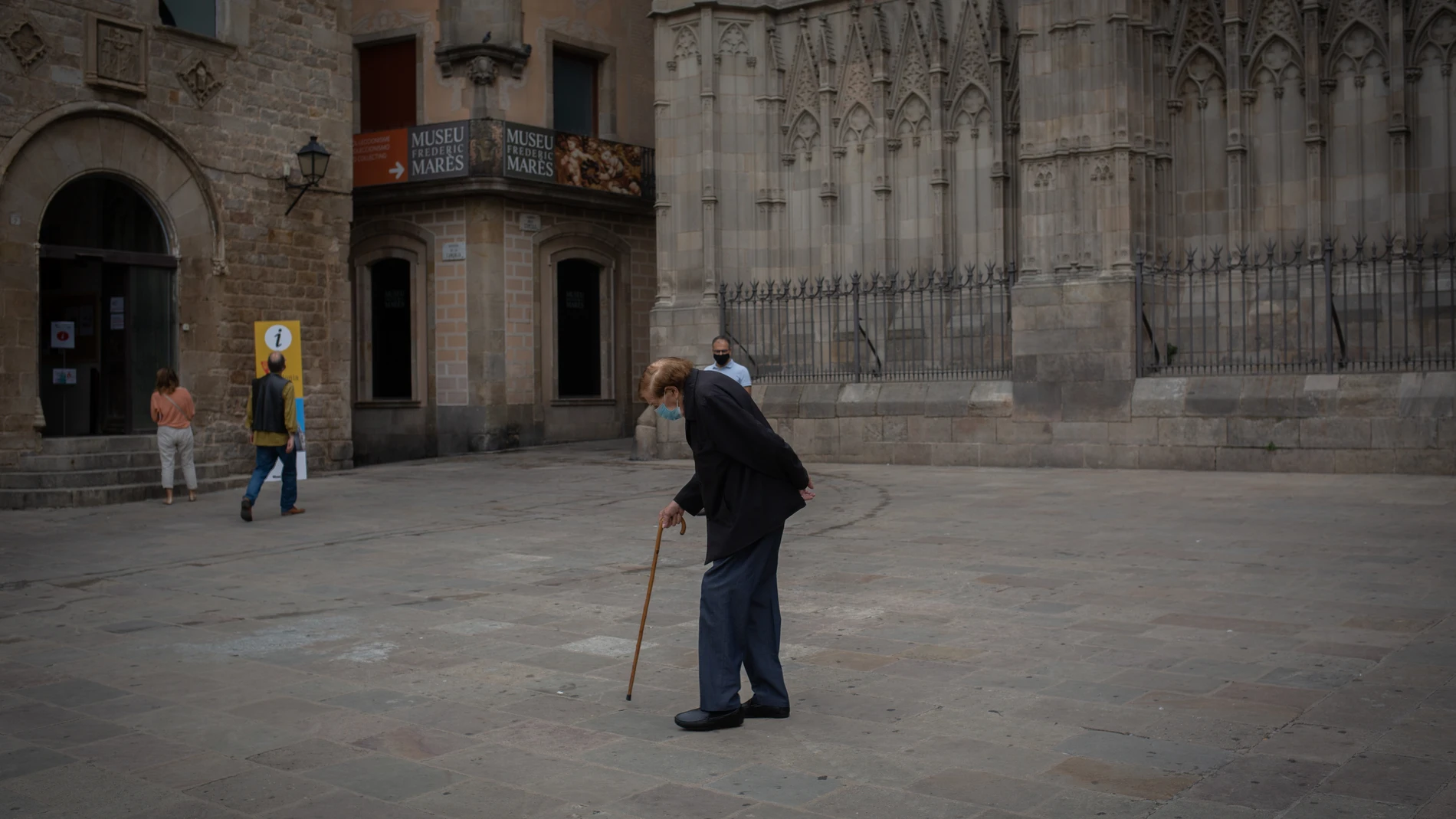 Un anciano camina por una plaza del Barrio Gótico de Barcelona