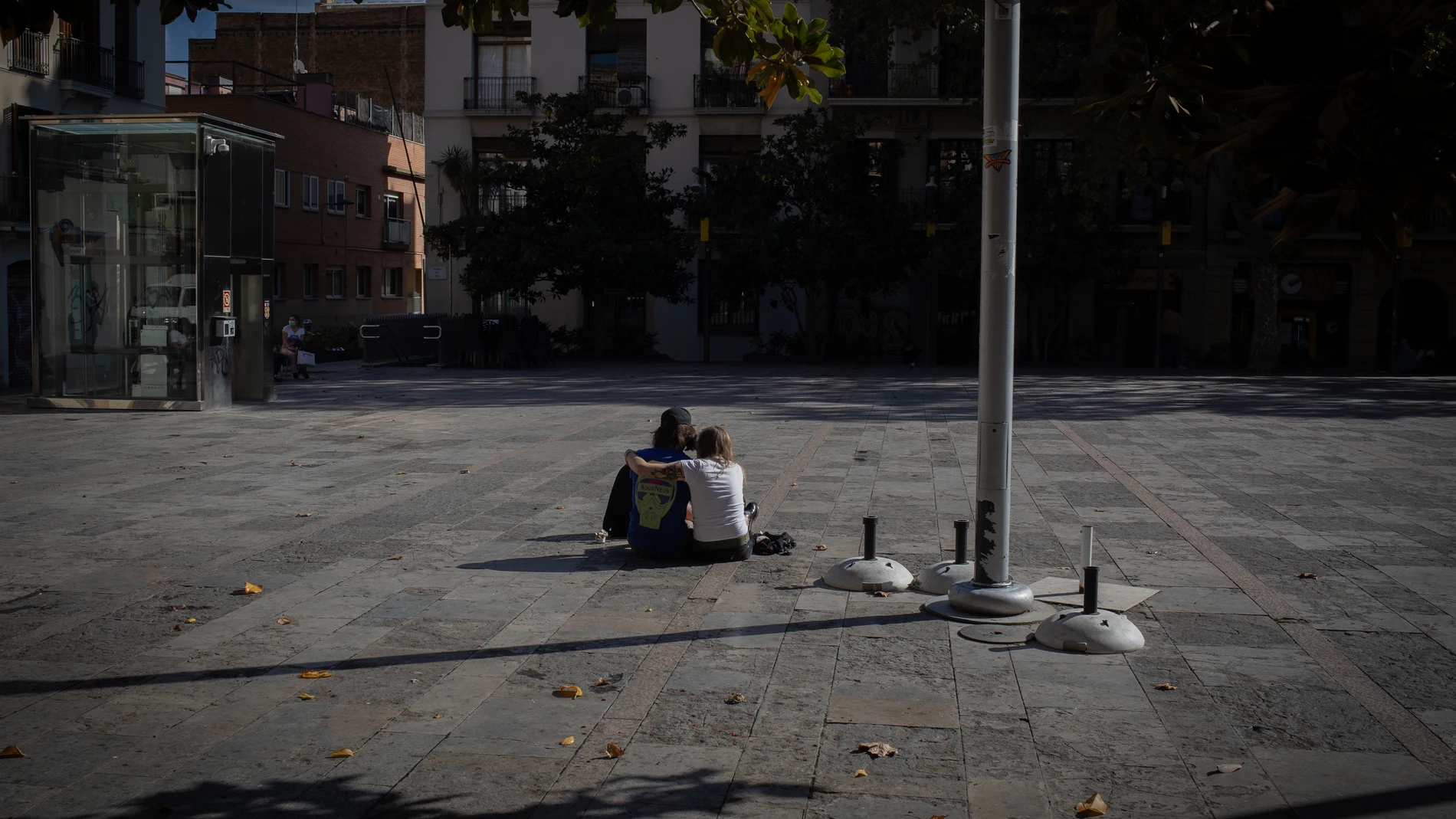 Una pareja sentada en la Plaza de la Virreina en Barcelona