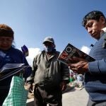 Varios simpatizantes del MAS leen un libro de Evo Morales en El Ato