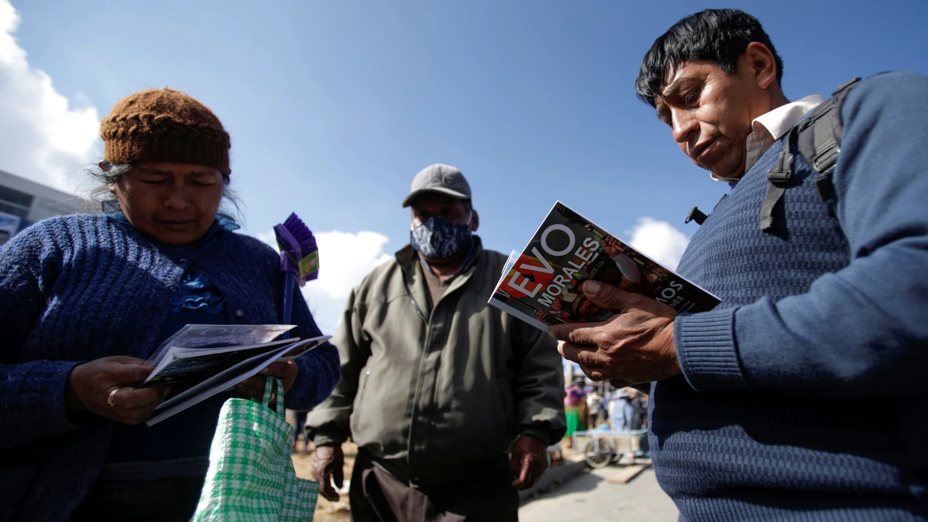 Varios simpatizantes del MAS leen un libro de Evo Morales en El Ato