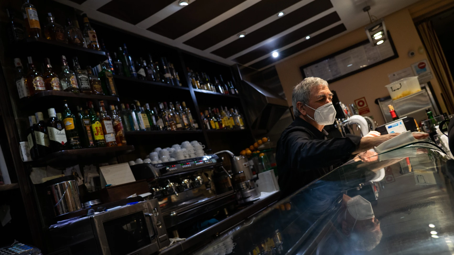 Ricardo, propietario del bar Bergantiños en Chamberí, recoge para cerrar cumpliendo con el nuevo horario establecido