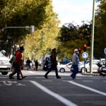 Varias personas cruzan la calle en la zona básica de salud de Guzmán el Bueno, en el distrito de Chamberí