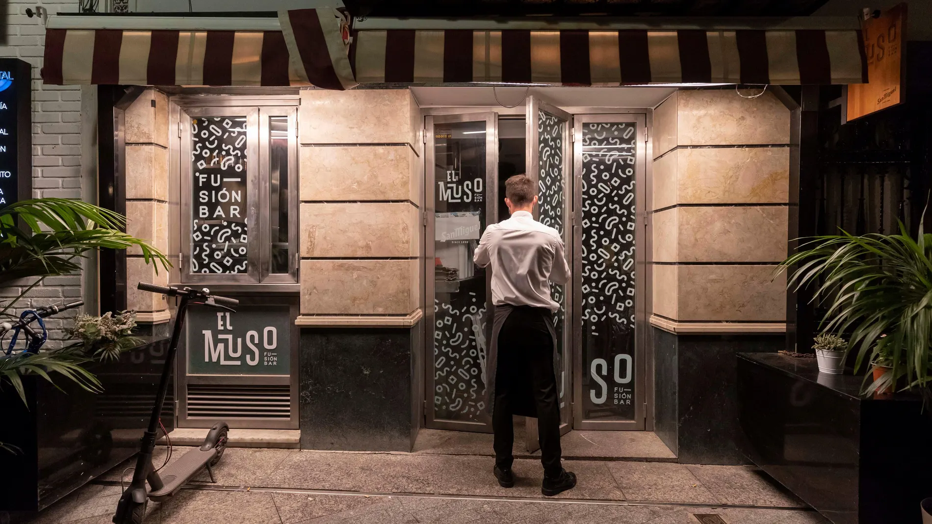 Un camarero cierra la puerta de un bar de la Plaza de Las Flores de Murcia