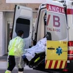 Un sanitario con equipo de protección especial para evitar contagios de coronavirus, traslada a un paciente de una ambulancia a urgencias del Hospital Clínico de València
