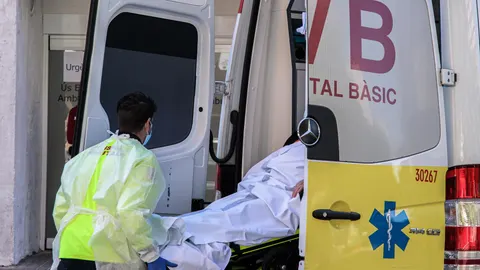 Un sanitario con equipo de protección especial para evitar contagios de coronavirus, traslada a un paciente de una ambulancia a urgencias del Hospital Clínico de València