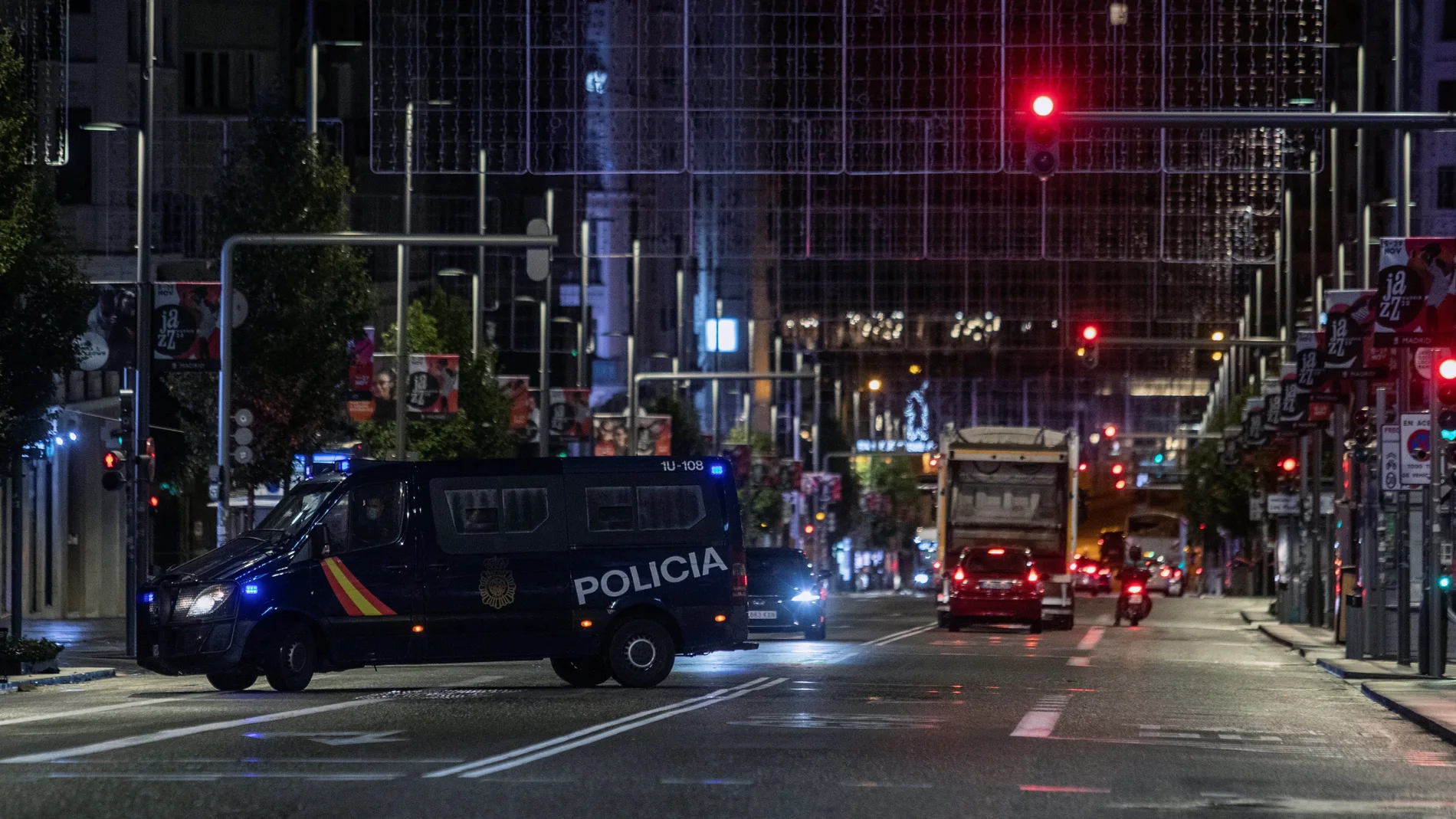 MADRID, 26/10/2020.- Un furgón de la Policía Nacional en la Gran Vía anoche, en la primera jornada de toque de queda en la capital. Esta medianoche ha comenzado el toque de queda en toda la Comunidad de Madrid que tendrá lugar de 00.00 a 6.00 horas mientras dure el estado de alarma en España, una medida que se suma a las restricciones de movilidad en 32 zonas básicas de salud de la región donde no estará permitido entrar ni salir salvo por motivos justificados, como ir a trabajar. EFE/Rodrigo Jiménez