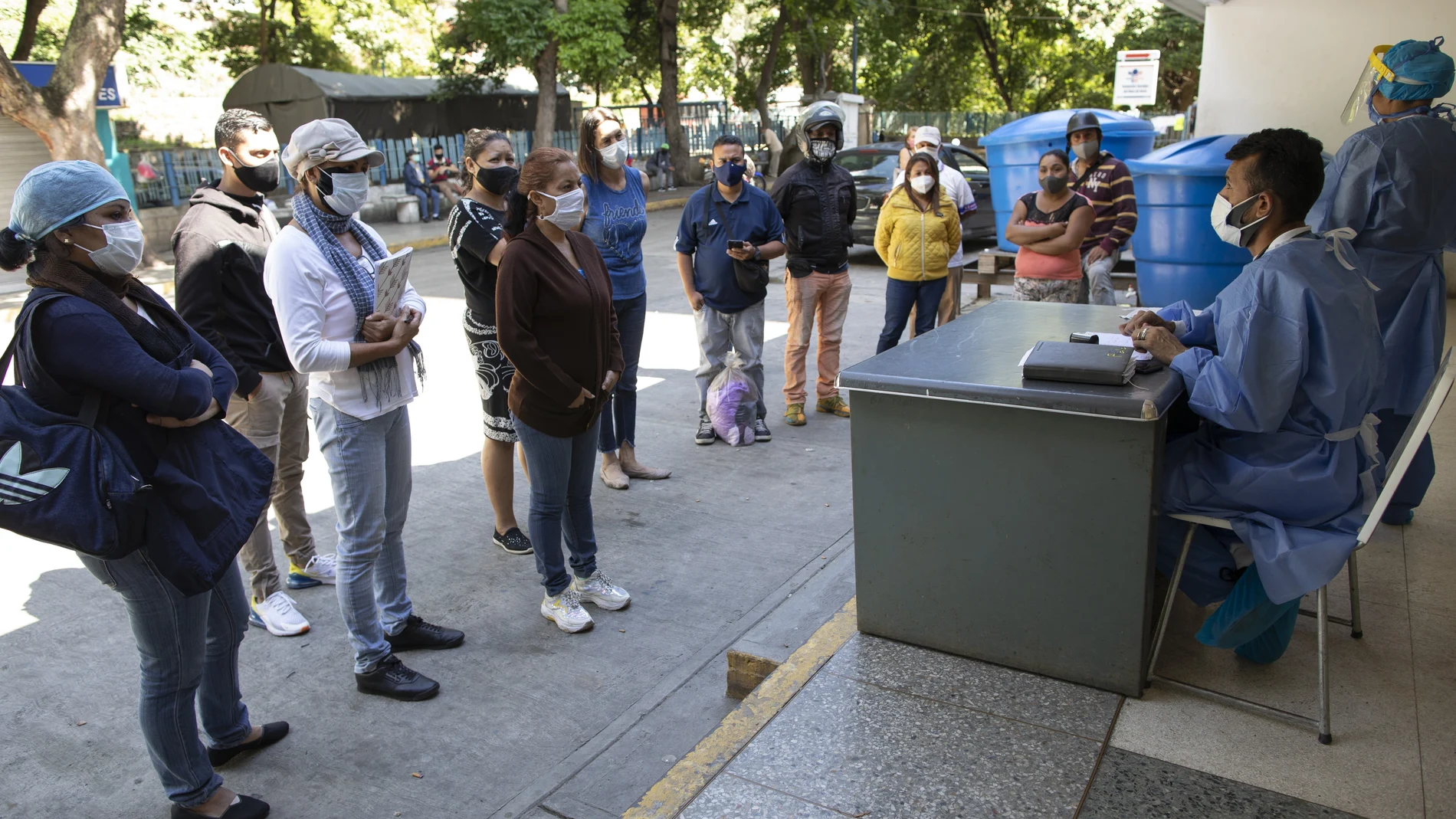 Dr. Wilfredo Sifontes, right, speaks to families who have family hospitalized in the COVID-19 wing, outside JosÃ© Gregorio HernÃ¡ndez Hospital in the Catia neighborhood of Caracas, Venezuela, Friday, Sept 4, 2020. Sifontes, who oversees the hospitalâ€™s emergency services including its coronavirus wing, described having a fever, cough and feeling sick. Though he oversees testing kits, he himself was never tested and continued to clock in. He dismissed the threat of the coronavirus, comparing it to a â€œcommon fluâ€ thatâ€™s sparked needless panic. (AP Photo/Ariana Cubillos)