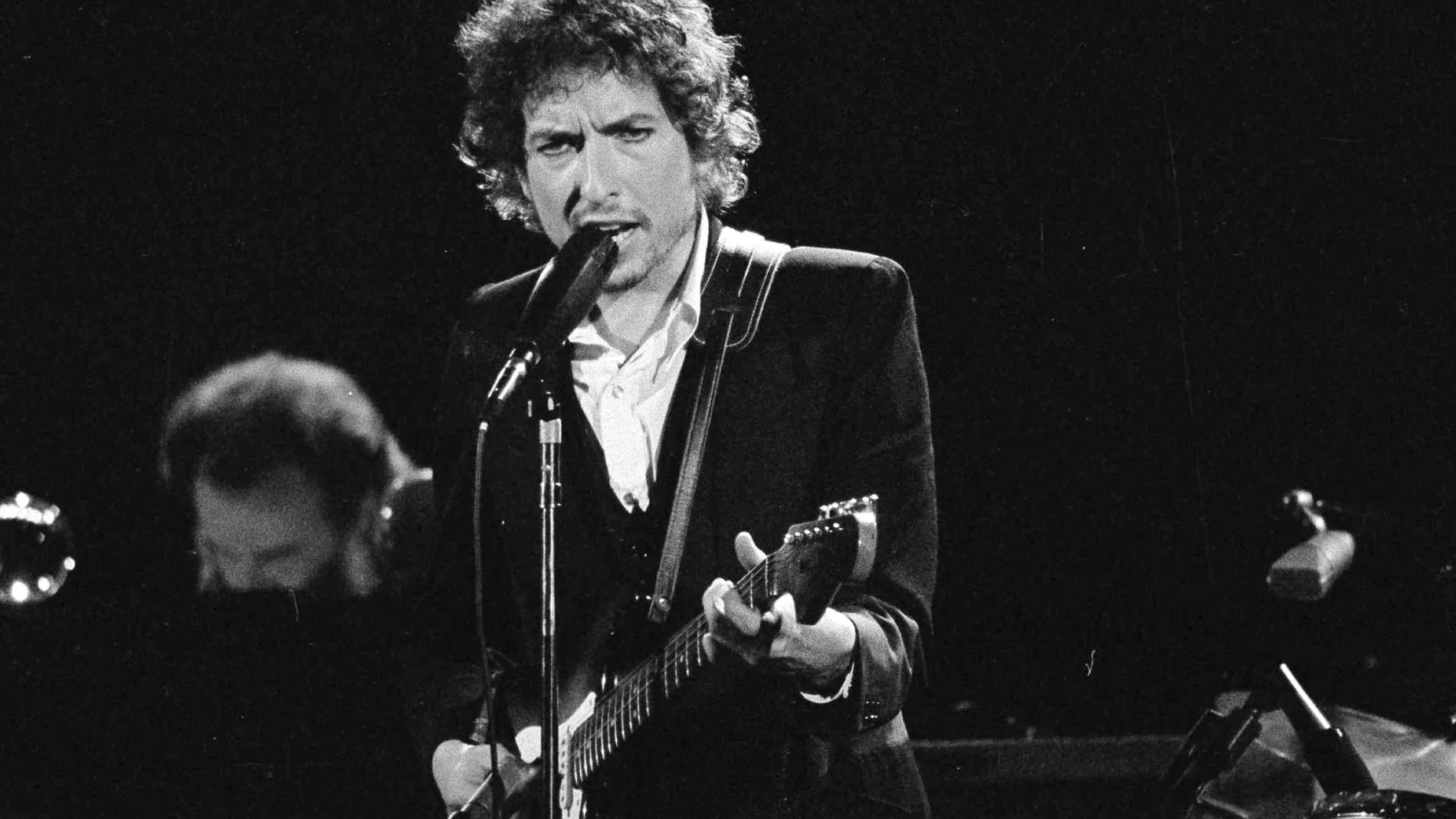 FILE - Musician Bob Dylan performs with The Band at the Forum in Los Angeles on Feb. 15, 1974. Transcripts of lost 1971 Dylan interviews with the late American blues artist Tony Glover and letters the two exchanged reveal that Dylan changed his name from Robert Zimmerman because he worried about anti-Semitism, and that he wrote "Lay Lady Lay" for actress Barbra Streisand. The items are among a trove of Dylan archives being auctioned in November 2020 by Boston-based R.R. Auction. (AP Photo/Jeff Robbins, File)