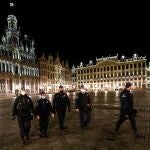 Varios agentes de policía patrullan la Grand Place de Bruselas por la noche